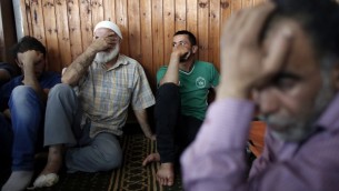 Les proches du bébé palestinien Ali Saad Dawabsha, tué après que sa maison a été incendiée, apparemment par des habitants des implantations juifs, en deuil à côté de son corps gisant dans une mosquée lors de ses funérailles dans le village cisjordanien de Douma le 31 juillet 2015. Hussein Dawabsha, le grand-père du bébé est visible sur la droite. (AFP PHOTO / THOMAS COEX)