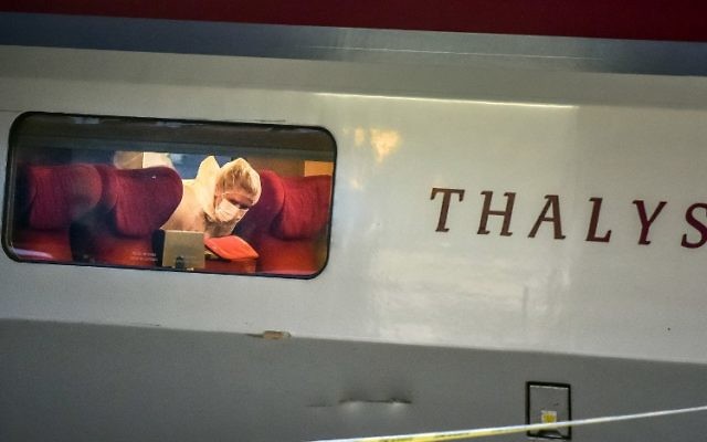 Un agent de police examine la scène du crime à l'intérieur d'un train Thalys la SNCF à la gare d'Arras, Nord de la France, le 21 août, 2015. Un homme armé a ouvert le feu dans un train blessant 3 personnes avant d'être maîtrisé par les passagers (Crédit : AFP PHOTO / PHILIPPE HUGUEN)
