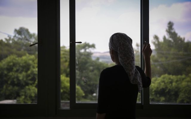 Une jeune femme religieuse regarde par la fenêtre (Hadas Parush/Flash90)