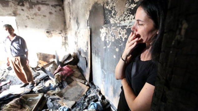 Une Israélienne dans la maison brûlée de la famille Dawabsha après l'attaque terroriste du 31 juillet 2015, à Duma, en Cisjordanie, le 2 août 2015. (Crédit : Yossi Zamir/Flash90)