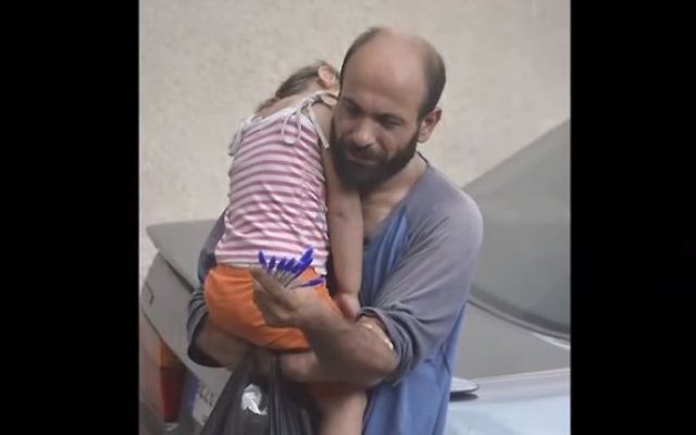 Le réfugié syrien-palestinien Adul Attar portant sa fille dans les rues de Beyrouth tout en vendant des stylos (Capture écran : YouTube)