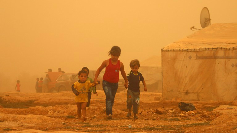 Les enfants syriens à pied au milieu de la poussière pendant une tempête de sable le 7 septembre 2015 au camp de réfugiés en périphérie de la ville libanaise  de Baalbek. (Crédit : AFP PHOTO / STR)