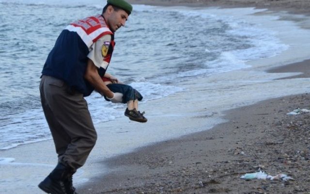 Un officier de police turc porte le cadavre d'un enfant migrant au large des côtes à Bodrum, au sud de la Turquie, le 2 septembre 2015 (Crédit : AFP / DOGAN AGENCE DE NOUVELLES)