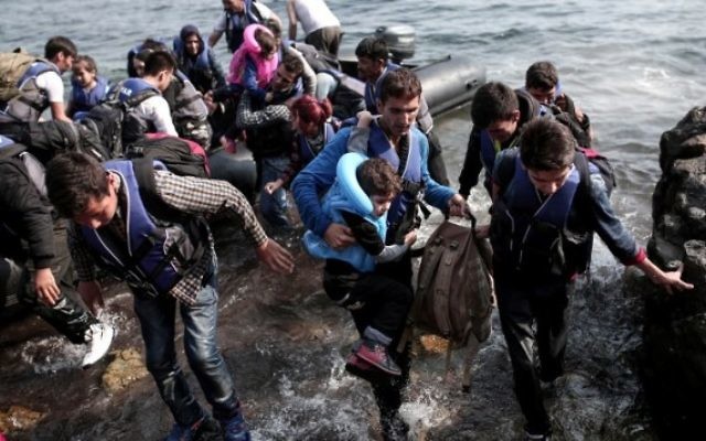 Des réfugiés syriens accostent sur l'île de Lesbos, après avoir traversé la mer Egée, le 3 septembre 2015 (Crédit : ANGELOS TZORTZINIS/ AFP)