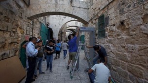 Les forces de sécurité israéliennes montent la garde pendant que les travailleurs installent un détecteur de métal dans le quartier musulman de la Vieille Ville de Jérusalem le 8 octobre 2015 après une série d'attaques au couteau. (Crédit : AFP Photo / Gali Tibon)