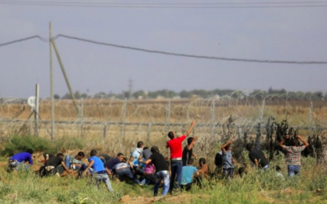 Des Gazaouis s'approchent de la clôture de la frontière avec Israël lors d'affrontements avec les soldats de Tsahal, le 9 octobre 2015. (Crédit photo: Mohammed Abed / AFP)