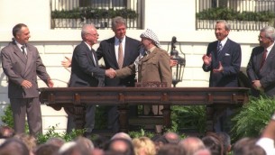 Bill Clinton regarde tandis qu'Yitzhak Rabin et Yasser Arafat se serrent la main lors de la signature historique des accords d'Oslo, le 13 septembre 1993 Tout à droite, il y a l'actuelle dirigeant palestinien Mahmoud Abbas (Crédit : GPO)