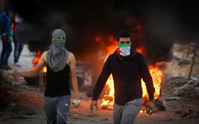 Des manifestants palestiniens jettent des pierres et brûlent des pneus lors d'affrontements avec les forces de sécurité israéliennes près du checkpoint de Hizma, en Cisjordanie, le 30 septembre 2015. Illustration. (Crédit : Flash90)
