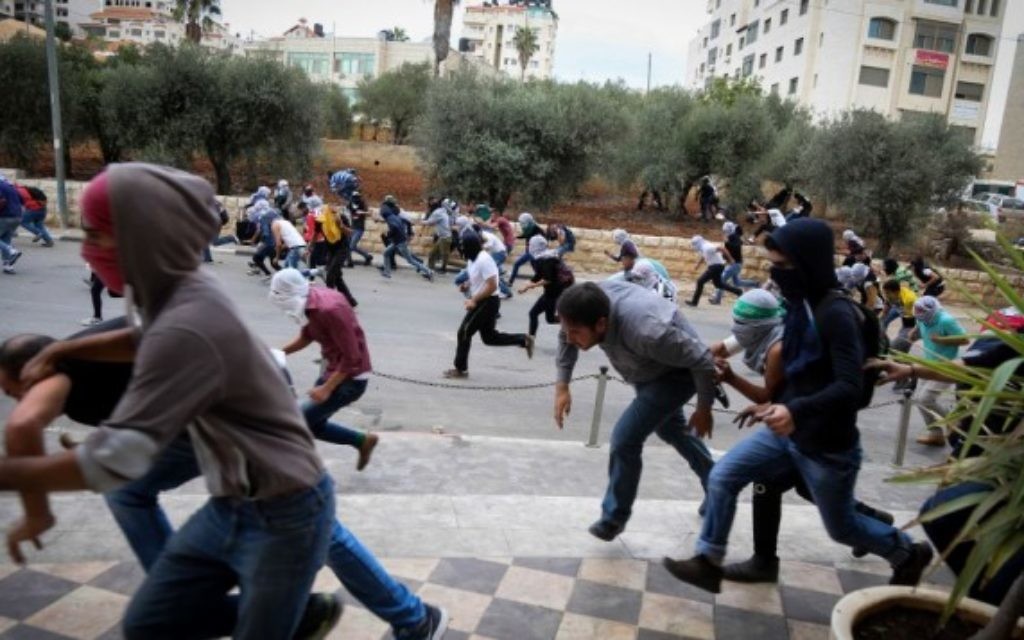 Des émeutiers palestiniens lançant des pierres pendant des affrontement avec les troupes israéliennes à Bet El, près de la ville cisjordanienne de Ramallah, le 10 octobre 2015 (Flash90)