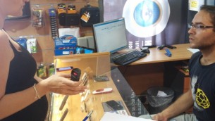 Une femme achetant un spray au poivre à Tel-Aviv (Crédit : Simona Weinglass / Times of Israël)