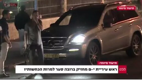 Une capture d'écran de de la Première chaîne montre le maire de Jérusalem, Nir Barkat, avec un pistolet. La légende dit : "le maire de Jérusalem porte, sans licence, une arme, malgré ses dénégations". (Crédit : Capture d'écran Première chaîne)