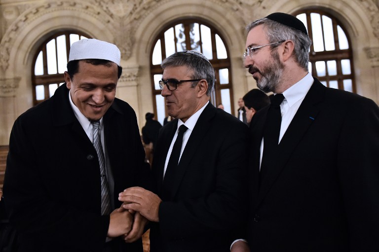 Le rabbin Moshe Sebbag (d) et l'imam de la mosquée de Drancy, Hassan Chalghoumi (g) arrivent à la Grande synagogue de la Victoire avant de rendre hommage aux victimes d'une série d'attaques meurtrières, le 15 novembre 2015. (Crédit : AFP PHOTO / LOIC VENANCE)