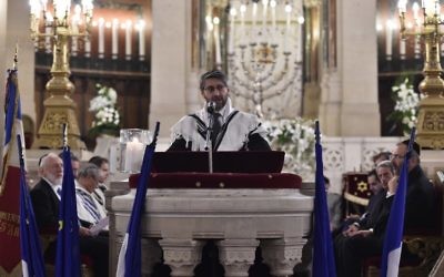 Le Grand Rabbin de France Haïm Korsia prie en hommage aux victimes d'une série d'attaques meurtrières à la Grande synagogue de la Victoire, le 15 novembre 2015. (Crédit : AFP PHOTO / LOIC VENANCE)