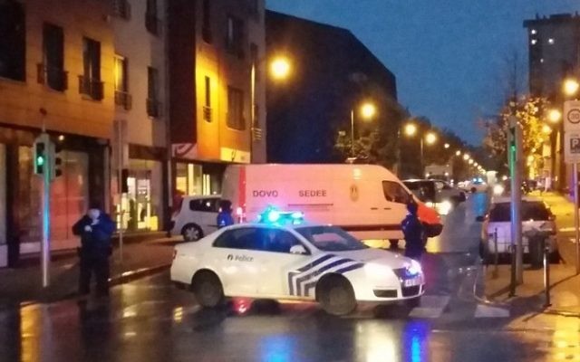 Une photo prise avec un téléphone portable le 14 novembre 2015 montre une camionnette de l'unité belge de déminage SEDEE tandis que les policiers bloquent une rue lors d'un raid de la police dans le quartier de Molenbeek à Bruxelles, peut-être en relation avec les attentats meurtriers du 13 novembre à Paris. (Crédit : AFP Photo / Belga / Hendrik Devriendt)