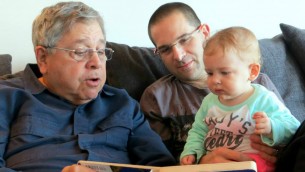 Richard Lakin (à gauche) lit un livre à sa petite-fille pendant que son fils Micah Avni regarde en janvier 2014 (Crédit : Autorisation)