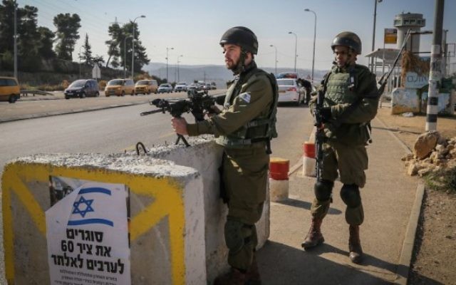 Des soldats israéliens sur l'intersection du Gush Etzion, un point de transit important pour la Cisjordanie, le 23 novembre 2015. Illustration. (Crédit : Gershon Elinson/Flash90)