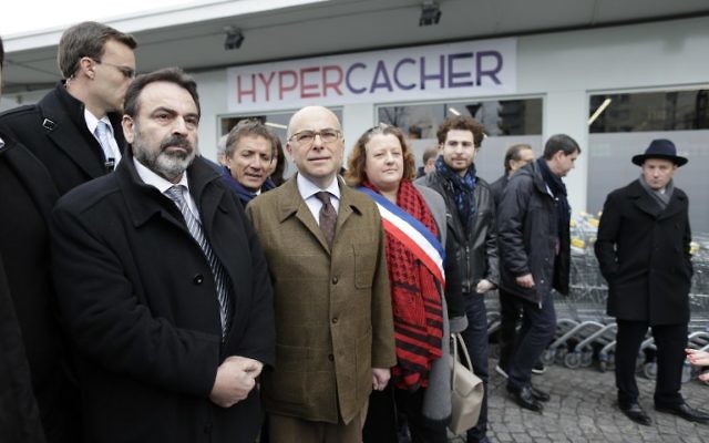 Le ministre français de l'Intérieur Bernard Cazeneuve (2e à partir de la gauche) et le président du Consistoire Joel Mergui (à gauche) le 15 mars 2015 devant le supermarché juif HyperCacher à Paris qui a été le site d'une prise d'otages sanglante lors d'une attaque djihadiste en janvier (Crédit photo: KENZO TRIBOUILLARD / AFP)