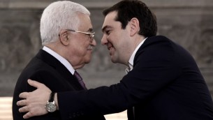 Le Premier ministre grec Alexis Tsipras (d) s'approche du président de l'Autorité palestinienne Mahmoud Abbas lors d'une conférence de presse après une réunion le 21 décembre 2015 à Athènes. (Crédit : ARIS MESSINIS / AFP)