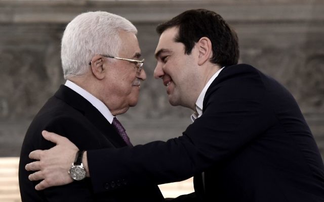 Le Premier ministre grec Alexis Tsipras (d) s'approche du président de l'Autorité palestinienne Mahmoud Abbas lors d'une conférence de presse après une réunion le 21 décembre 2015 à Athènes. (Crédit : ARIS MESSINIS / AFP)
