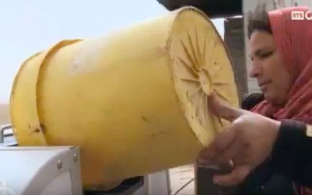 Une Bédouine verse des déchets dans une machine à fabriquer du gaz (Crédit : capture d’écran YouTube)