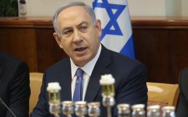 Le premier ministre Benjamin Netanyahu, au début de la réunion hebdomadaire du cabinet ministériel à Jérusalem, à côté d'une menorah prête pour le premier soir de la fête juive de Hanouka, 6 décembre 2015 (Crédit : Emil Salman/Haaretz)