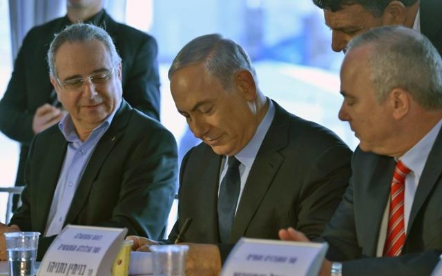 Le Premier ministre Benjamin Netanyahu (au centre) signe la clause 52 de la loi anti-trust pour approuver l'accord gazier, le 17 décembre 2015. (Crédit : Kobi Gidon / GPO)