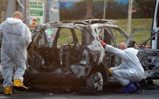 Des policiers israéliens examinant une voiture qui a explosé dans la ville de Petah Tikvah, le 3 février 2014. (Crédit photo: Gideon Markowicz / Flash90)