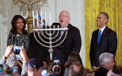 Le président Reuven Rivlin allume la menorah de Hanoukka , en présence du président américain Barack Obama, de Michelle Obama, et de Nechama Rivlin, à la Maison Blanche, le 9 décembre 2015. (Crédit : capture d'écran YouTube/The White House)