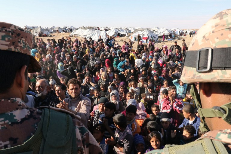 Les réfugiés syriens, bloqués entre les frontières jordaniennes et syriennes, qui attendent pour traverser en Jordanie, au passage de la frontière de Hadalat, à l'est de la capitale jordanienne Amman, le 14 janvier 2016 (Crédit : AFP / KHALIL Mazraani)