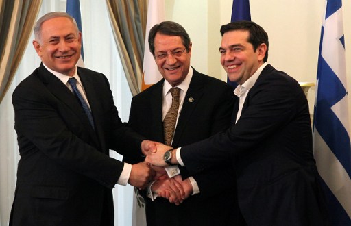 Le président chypriote, Nicos Anastasiades (au centre), le Premier ministre israélien Benjamin Netanyahu (à gauche) et le Premier ministre grec, Alexis Tsipras se serrant la main lors de leur rencontre au palais présidentiel à Nicosie, à Chypre, le 28 janvier 2016 (Crédit : POOL/AFP / Yiannis Kourtoglou)