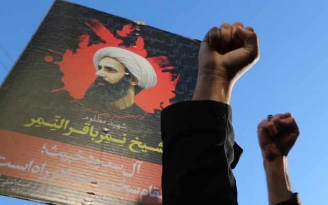 Iraniens devant un portrait du dignitaire religieux chiite Nimr al-Nimr, pendant une manifestation contre son exécution par les autorités saoudiennes, devant l'ambassade d'Arabie Saoudite à Téhéran, le 3 janvier 2016. (Crédit : Atta Kenare/AFP)