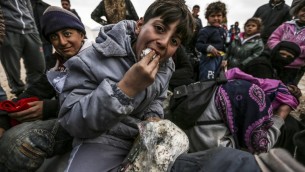 Des réfugiés syriens qui ont fuit la ville assiégée d'Alep attendent à Bab al-Salama, dans le nord de la Syrie, près de la frontière turque, le 6 février 2016. (Crédit : AFP/Bulent Kilic)