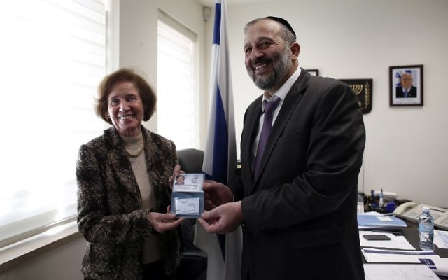 Beate Klarsfeld, reçoit une carte d'identité israélienne des mains d'Aryeh Deri, le 15 février 2016 (Crédit : AFP / THOMAS COEX)
