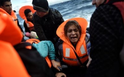 Des réfugiés et des migrants arrivant à l'île grecque de Lesbos après avoir traversé la mer Égée de la Turquie, le 1er octobre 2015. (Crédit : AFP/Aris Messinis)