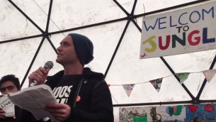 Jude Law lit une lettre ouverte de Lion Feuchtwanger adressée aux nazis pendant une représentation intitulée « Les lettres vivent », où des lettres considérées comme pertinentes pour la situation critique des réfugiés ont été lues, dans le camp de réfugiés de Calais, le 21 février 2016. (Crédit : capture d'écran YouTube/Help Refugees)