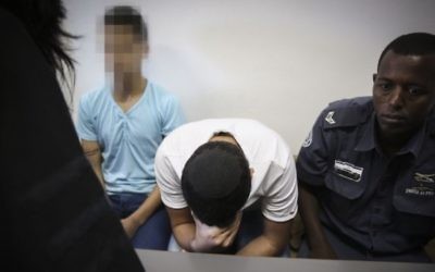 La police encadre deux mineurs juifs qui ont pris part à l'enlèvement et au meurtre de Mohammed Abu Khdeir, à la cour du district de Jérusalem, le 3 juin 2015. (Crédit : Hadas Parush/Flash90)