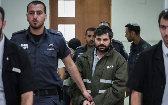 Yossef Ben David (en vert), l'un des suspects dans l'assassiner juifs de Muhammed Abu Khdeir, sous escorte policière à la cour de district de Jérusalem, le 8 juin 2015 (Crédit : Hadas Parush / Flash90)