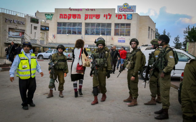 Des soldats israéliens en dehors d'un supermarché Rami Levy au gush Etzion en Cisjordanie, où un terroriste palestinien a blessé une femme israélienne le 28 octobre 2015 (Crédit : Gershon Elinson / Flash90)