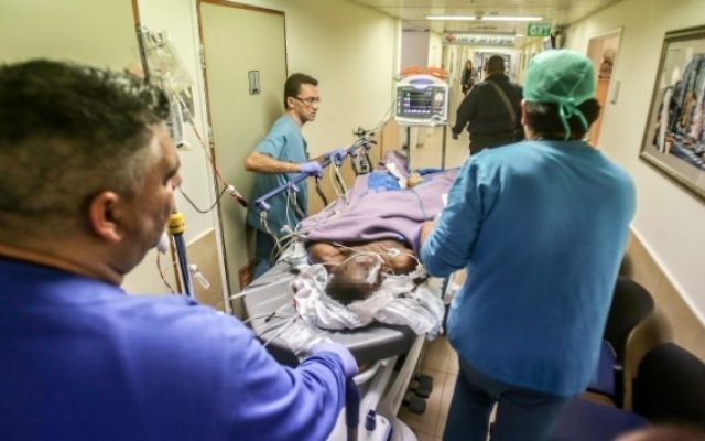 Le personnel médical emmène Kamel Hassan Mohammed dans le service des urgences de l'hôpital Barzilai à Ashkelon, après son attaque au couteau contre un soldat israélien, le 7 février 2016. (Crédit : Edi Israel/Flash90)