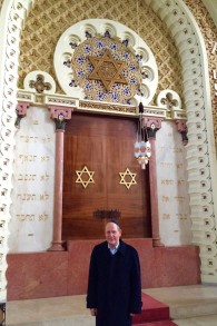 Le porte-parole de la communauté juive de Porto, Michael Rothwell, posant devant l'arche dans la synagogue Mekor Haim à Porto, au Portugal, le 28 janvier 2016 (Crédit : Rachel Delia Benaïm / Times of Israël)