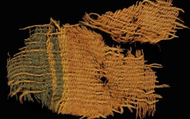 Un beau tissus de laine teint en rouge et bleu. Le tissus utilise les différentes couleurs de poils naturels pour créer des couleurs noir et orange-brun pour les bandes décoratives (Crédit : Clara Amit / Israel Antiquities Authority)