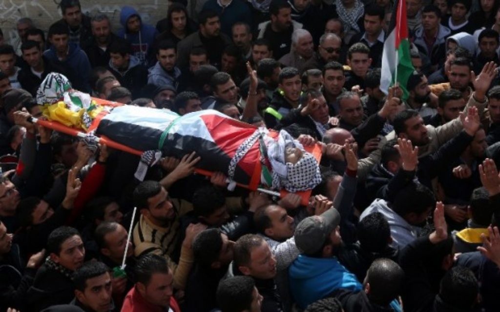 Des Palestiniens portent le corps d'Amjad Abu Omar Sakari, qui a été abattu pendant qu'il menait une attaque contre des soldats israéliens près de l'implantation de Beit El, pendant ses funérailles à Jamain, un village du sud de Naplouse, le 1er février 2016. (Crédit : AFP / JAAFAR ASHTIYEH)