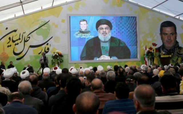 Des partisans du groupe terroriste chiite libanais Hezbollah regardent un discours télévisé de son dirigeant, Hassan Nasrallah, à Insar, au sud du Liban, le 6 mars 2016. (Crédit : AFP/Mahmoud Zayyat)