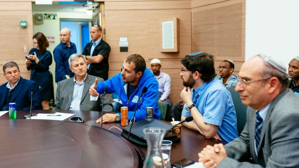David, immigrant de l'ex-URSS (en pull bleu) témoigne devant la commission de l'Alyah de la Knesset. Depuis la gauche, sont également présent le rabbin de Giyur KaHalacha Seth Farber, Eli Cohen, directeur, et l'avocat Elad Caplan. A Jérusalem, le 8 mars 2016. (Crédit : Michael Shapochnic, Giyur KaHalacha) 