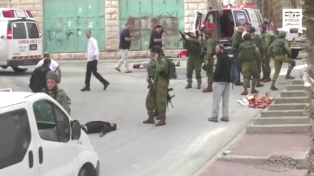 Un soldat israélien chargeant son arme avant de sembler tirer à la tête sur un assaillant palestinien au sol, apparemment désarmé, à la suite d'une attaque au couteau à Hébron, le 24 mars 2016. (Crédit : capture d'écran B'TSelem)