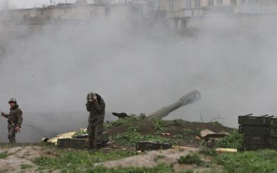 Des militaires arméniens de l'armée d'autodéfense du Nagorny-Karabakh en train de tirer un obus d'artillerie en direction des forces azéries de leurs positions dans la ville de Martakert dans la région azerbaïdjanaise de Nagorny-Karabakh, le 3 avril 2016. (Crédit : Vahram Baghdasaryan/Photolure/AFP)