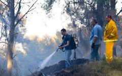 Les pompiers israéliens s'affairent à éteindre un feu de forêt, dans la forêt de Biriya, près de Safed, au nord d'Israël, le 25 avril 2016. (Crédit photo : Basel Awidat/Flash90)