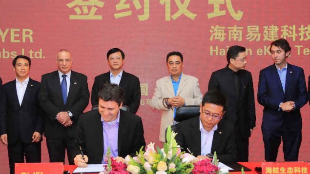 Asaf Gendler, CEO de la start-up israélienne Bidflyer (au premier plan à gauche) et Kevin Yu, COO de Hainan Eco-Tech Group (au premier plan à droite), pendant la signature d'un accord de partenariat. (Crédit : autorisation)