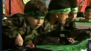 Des petites garçons palestiniens jouent avec de fausses armes dans une pièce de théâtre jouée à Gaza dans le cadre du Festival de Palestine pour les enfants et l'éducation, en avril 2016. (Crédit : capture d'écran Deuxième chaîne)