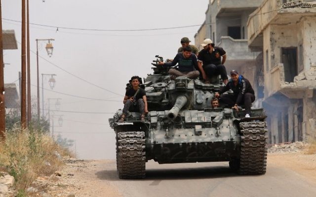 Les combattants de l'opposition conduisant un char dans une zone tenue par les rebelles de la ville syrienne de Daraa, lors de nouveaux affrontements avec des partisans du régime le 10 mai 2016 (Crédit : AFP Photo / Mohamed Abazeed)